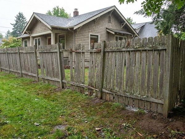 Leaning gray cedar fence before, example